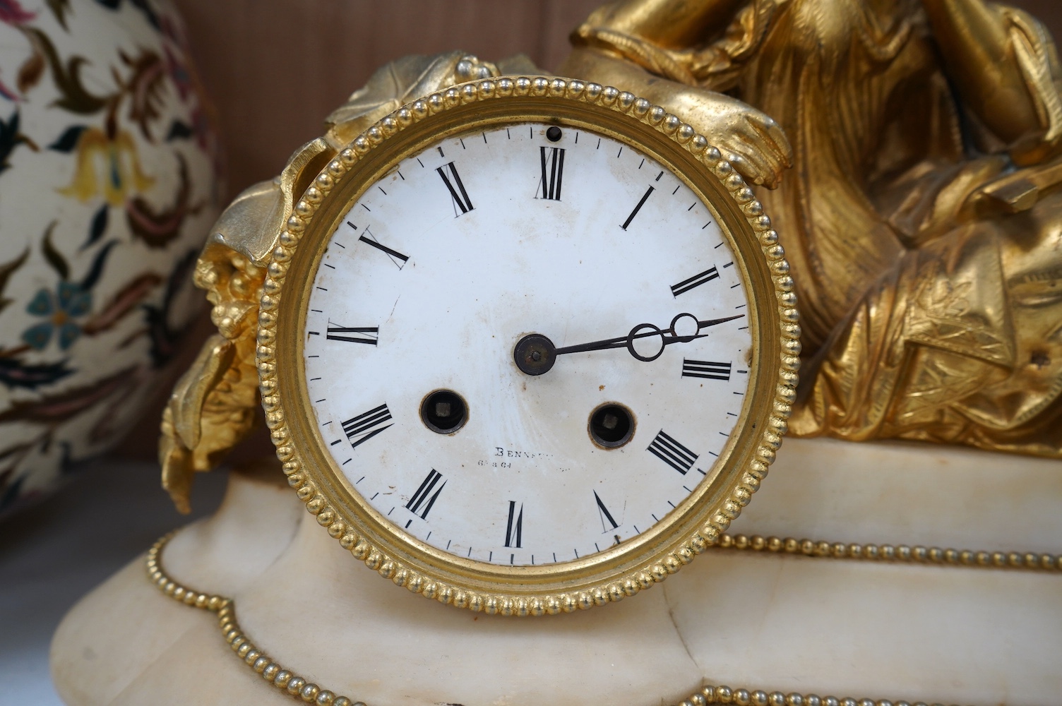 A 19th century white marble mantel clock with enamel dial, surmounted with a gilt spelter figure, with key, 46cm wide. Condition - fair, untested